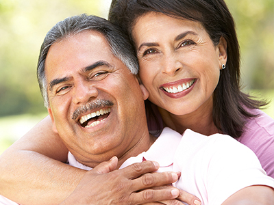 The image shows a man and woman embracing each other with smiles on their faces, suggesting a close relationship between them.