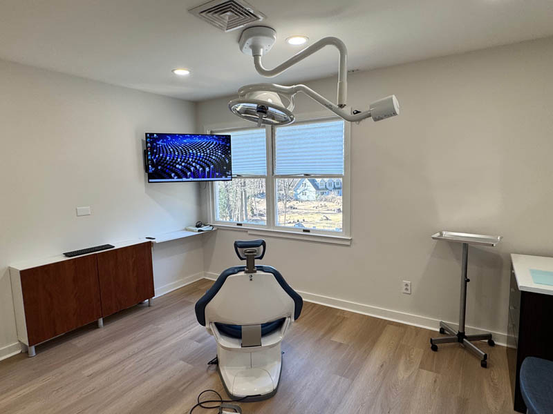 A dental office with a modern chair and equipment, ready for a dental procedure.
