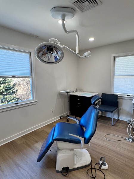 A dental office with a blue chair and equipment.